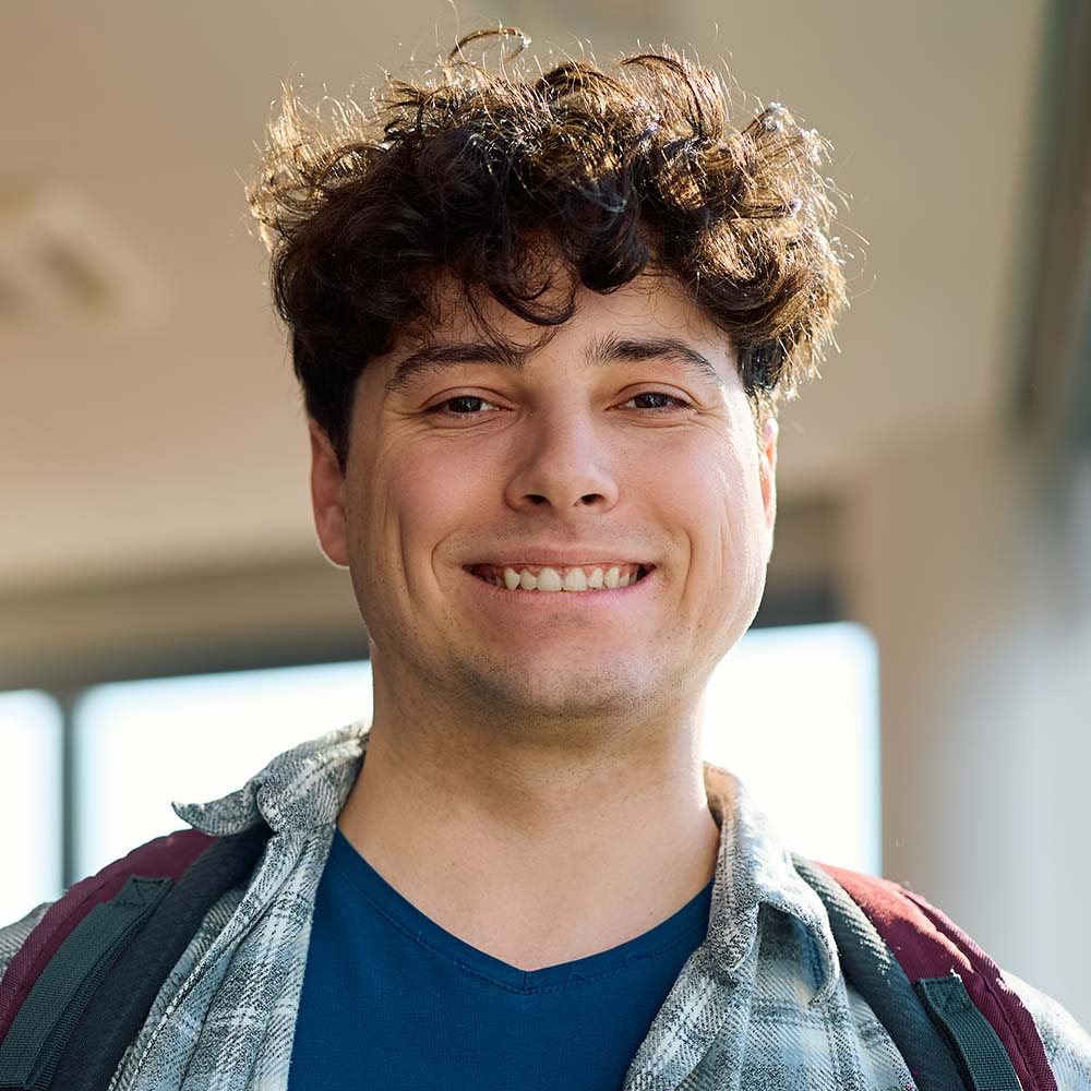 happy student at university classroom looking at c TZ5ZT5G